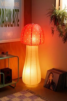 a mushroom shaped lamp sitting on top of a table next to a potted plant