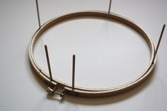 a close up of a circular object on a white surface with pins sticking out of it