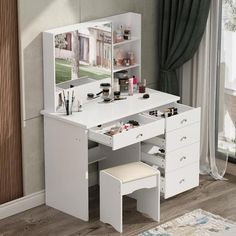 a white dressing table with drawers and a mirror on it's side, in front of a window