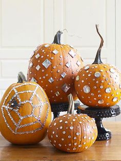 some pumpkins are sitting on a table with white and black dots painted on them