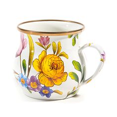 a white and gold coffee cup with flowers painted on the side, sitting in front of a white background