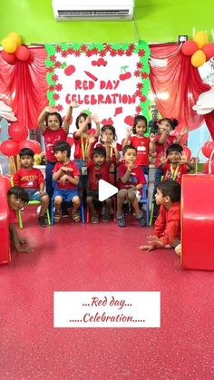 a group of children sitting on top of red chairs in front of a sign that says red day celebration