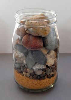 a glass jar filled with rocks and gravel