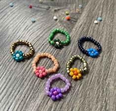 six beaded bracelets sitting on top of a wooden table