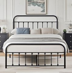 a black metal bed frame in a white bedroom