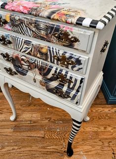 a white dresser with zebra print drawers on it