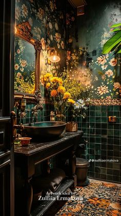 a bathroom with green tiles and flowers on the wall, along with a black sink