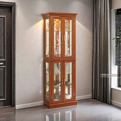 a tall wooden cabinet with glass doors in a living room next to a door way