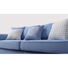 a blue couch with four pillows on it's back and one pillow in the middle