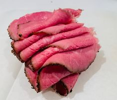 slices of meat sitting on top of white paper