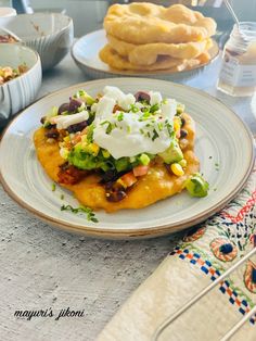 mexican food on a plate with other dishes in the background