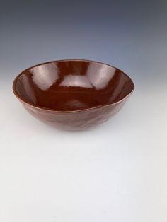 a brown bowl sitting on top of a white table