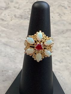 Vintage Genuine Opals and Ruby Ring  Gold plated pure silver ring and setting  Size 5 3/4 Colorful opals Oval Opals each measure 5 x 3 mm with a 2 mm depth  Round cut simulated ruby measures 4 mm with a 2 mm depth  Beautiful Victorian Style Cocktail Ring! October and July Birthstones 1970-1980's ring Star seller shop Over 600 pieces sold on Etsy Hand set by experienced jeweler  Free Shipping! Victorian Style Rings, Ruby Ring Gold, Opal Band, And July, Opal Ring, Multi Stone Ring, Ruby Ring, Ring Gold, Victorian Style