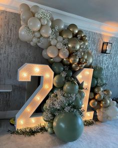 balloons and garlands are arranged around the number twenty