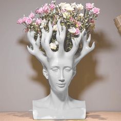 a white sculpture with flowers in it's head