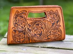 a brown leather purse sitting on top of a wooden table