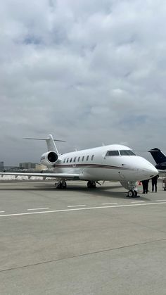 an airplane is parked on the tarmac with people around it