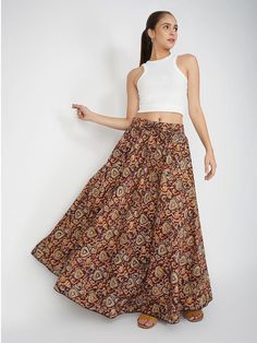 Our Venessa printed skirt, made from soft cotton fabric, features an A-line silhouette perfect for most body types. This regular-fit Kalamkari skirt with an elasticated waistband is a great option for all-day wear, especially during the summer months. Kalamkari is a highly popular form of block-printed cotton textile produced with the help of kalam, meaning pen. During the process, a sharp-pointed pierced bamboo regulates the flow of color/organic dye on the fabric. This maroon-colored skirt comes with one pocket, making it an ideal casual-wear wardrobe staple. To add some extra fun, you can pair it with a monotone shirt or top and elevate your style effortlessly. Material: Cotton Style/Print: Kalamkari Waist: 30” Length: 39” Fit: A-line Occasion: Casual Color: Maroon Lining: No Kalamkari Skirts, Blue Lily, Cotton Textile, Printed Skirt, Skirt For Women, Summer Months, Matching Dresses, Printed Skirts, Cotton Style