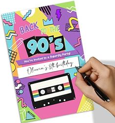 a hand holding a pen writing on top of a birthday party card with the words, back to the 90's