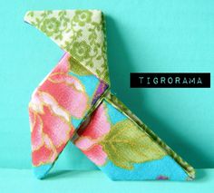 an origami bird made out of fabric on a blue background with the words tigrorama written below it