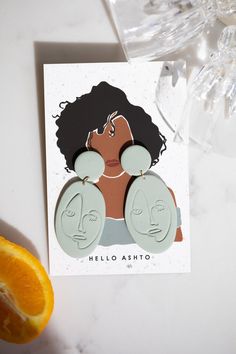 a card with an image of a woman's face and two earrings on it