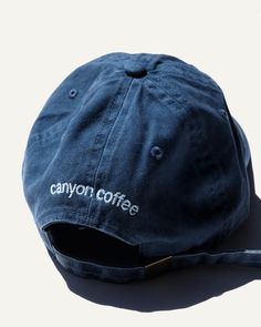 This classic cap is embroidered with the location of our first shop and neighborhood we call home — Echo Park. Canyon tested and approved for roasting, drinking coffee, cooking, hiking, road trips, beaches, and picnics.In a washed navy cotton with an adjustable size. The Canyon Coffee logo is subtly embroidered on the back. Product Details: - Washed Navy Color- Adjustable size Coffee Shop Merch, Canyon Coffee, Varsity Jacket Outfit, Cap Store, Fresno State, Coffee Subscription, Coffee Logo, Coffee Scoop, Drinking Coffee