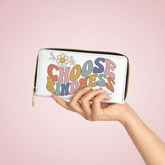 a woman's hand holding a white purse with the words choose kindness on it