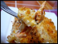 a close up of food on a fork with cheese and meat in the middle,