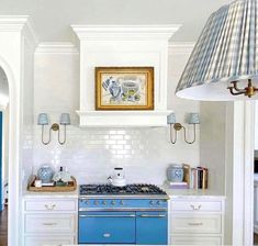 a blue stove top oven sitting inside of a kitchen next to a white counter top