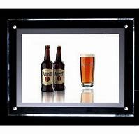 two beer bottles are sitting next to each other in front of a framed glass frame