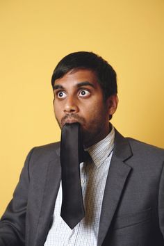 a man in a suit is holding his nose to his mouth