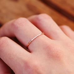 a woman's hand with a diamond ring on her left wrist and the other hand is holding it