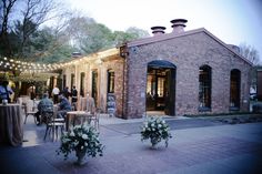 an outdoor venue with tables, chairs and string lights