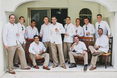 a group of men standing and sitting in front of a building