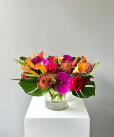 a vase filled with colorful flowers on top of a white table