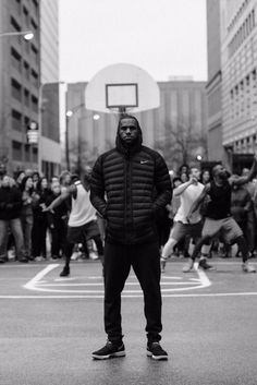 a man standing on top of a basketball court in front of a group of people