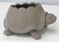 a small turtle toy sitting on top of a white surface