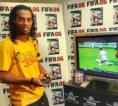 a man standing in front of a tv holding a game controller and looking at the camera