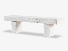 a white bench sitting on top of a cement block