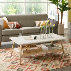 a living room filled with furniture and a large window covered in lots of natural light