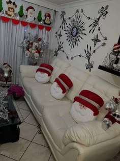 a living room filled with white couches covered in santa claus hats and red mittens