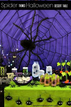 a table topped with lots of halloween decorations and spider webs on top of it