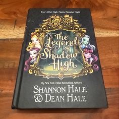 the legend of shadow high by shannon hale and dean hale is on top of a wooden table