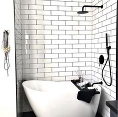 a white bath tub sitting in a bathroom next to a shower head and faucet