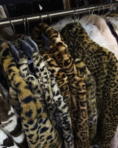 several different colored furs are hanging on a rack