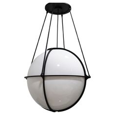 a large white ball hanging from a black metal light fixture on an isolated ceiling lamp