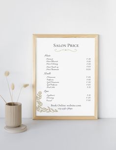 a white framed menu sitting on top of a table next to a vase