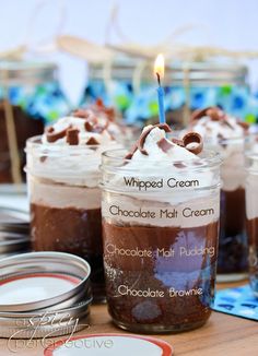 several jars filled with desserts sitting on top of a table