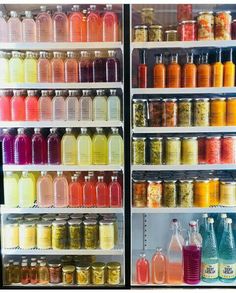 the refrigerator is filled with many different types of drinks and juices for sale on the shelves