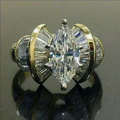 an engagement ring with two pear shaped diamonds on the side and three baguettes in the middle